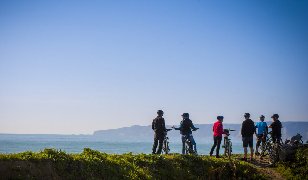 Cycling, with Cape Kidnappers in background (credit Takaro Trails)