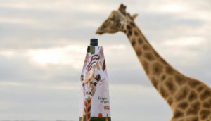 Long giraffe neck arching over a wine bottle